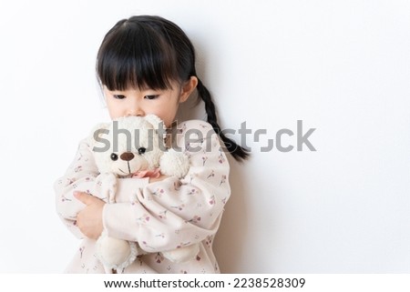 A child hugging a stuffed bear