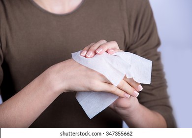 Child Hygiene.Little girl cleaning her hands with a wet baby wipe isolated on a white background. - Shutterstock ID 347355662
