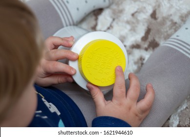 A Child Independently Tries To Open A Plastic Bottle Of Medicine, Close-up. Child-resistant, Childproof Or CR Packaging. Push&Turn Cap. Child Safety Concept