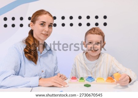 Child interacting with developmental toy during learning session with teacher, focusing on education and cognitive development