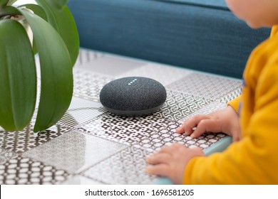 Child Interacting With Smart Home Assistant Speaker