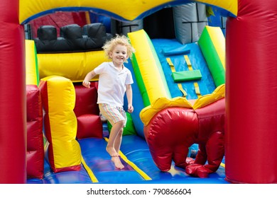 Child jumping on colorful playground trampoline. Kids jump in inflatable bounce castle on kindergarten birthday party Activity and play center for young child. Little boy playing outdoors in summer. - Shutterstock ID 790866604