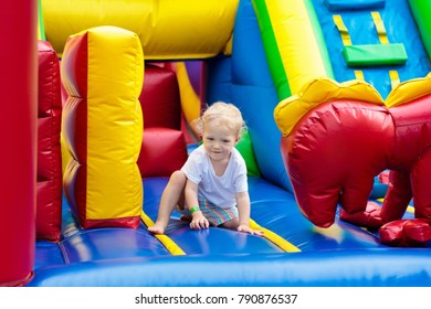 Child jumping on colorful playground trampoline. Kids jump in inflatable bounce castle on kindergarten birthday party Activity and play center for young child. Little boy playing outdoors in summer. - Shutterstock ID 790876537
