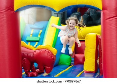 Child jumping on colorful playground trampoline. Kids jump in inflatable bounce castle on kindergarten birthday party Activity and play center for young child. Little girl playing outdoors in summer. - Shutterstock ID 790897867