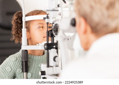 Child, kid or girl in optometry eye exam with optometrist, ophthalmologist or consulting medical profession and clinic slit lamp. Eye test, children eye care or vision check for healthcare insurance - Powered by Shutterstock