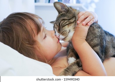 Child Is Kissing A Cat