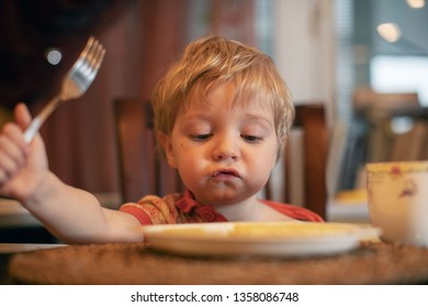 Child In The Kitchen Eating Spagetti. Close-up Portrait