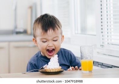 a child in the kitchen eats cake and screams with delight
