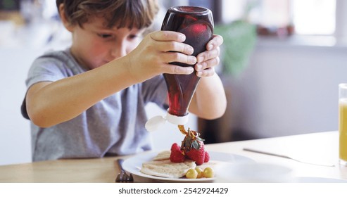 Child, kitchen and pancakes for breakfast with fruit as food, nutrition and diet in home for morning. Young boy, hungry and syrup for brunch, cooking and delicious meal with preparing or ingredients - Powered by Shutterstock