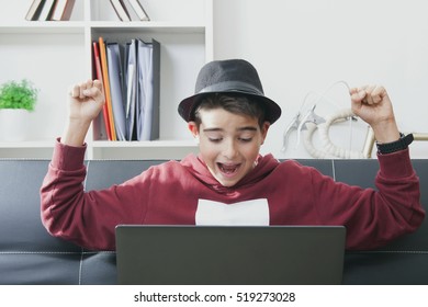 child with laptop celebrating success with enthusiasm