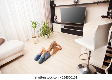 Child Laying On The Floor And Watching TV At Home