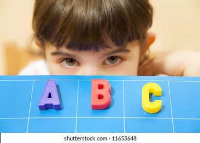 child learning the ABC's. The focus is on the letters