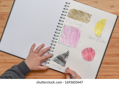 Child Learning At Home. Pre School Age Child Learning About Shapes And Hand Writing