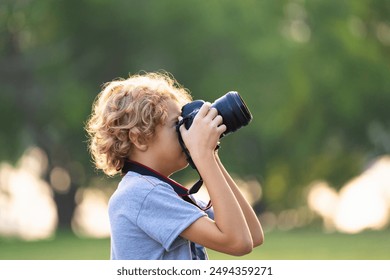 Child learning to take photos. Kid photographer. Little boy watching birds and making images with professional camera. Parent teaching son to photograph wildlife. Young creative artist. - Powered by Shutterstock