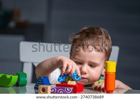 Child learning through play while stacking wooden blocks in a calm home environment.