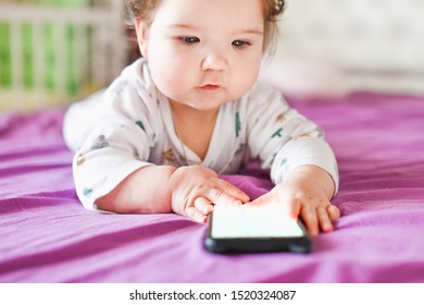 Child Learns By Mobile Phone. Little Newborn Baby Reaching For A Mobile Phone 