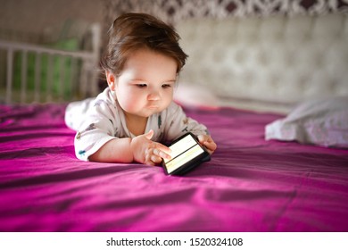 Child Learns By Mobile Phone. Little Newborn Baby Reaching For A Mobile Phone 