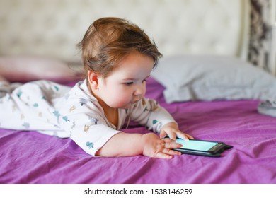 Child Learns By Mobile Phone. Little Newborn Baby Reaching For A Mobile Phone 