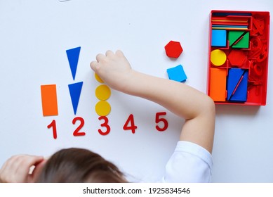 The child learns Number line and geometric shapes. The preschooler works with Montessori material. Educational logic toys for kid's. Children's hands close-up. Montessori Games for Child Development