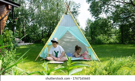 The Child Learns To Read. The Boy Reads The First Children's Book On Syllables. Children Spend Summer Holidays In The Countryside In The Garden. Ideas Of Children's Activities Without Parents.