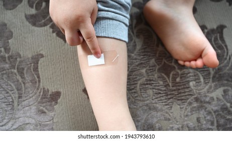 Child Leg With An Adhesive Bandage. Childhood Trauma Concept. High Quality Photo