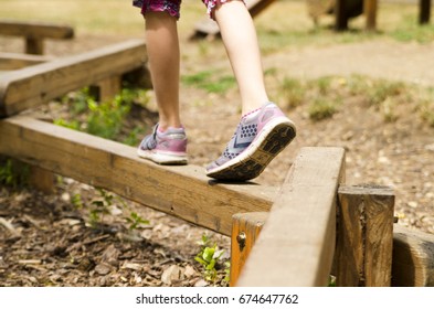 Child Leg Play Balance On Wooden Beam In Park. 