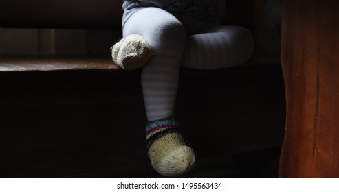 Child Legs Under Table. Little Boy Sitting At The Kitchen Table. Breakfast.