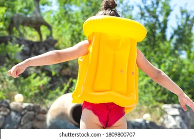 A Child With A Life Vest In The Pool