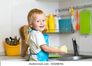 Child Little Boy Helping Mother Washing Dishes In The Kitchen