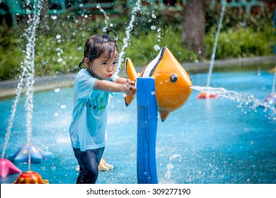 Child Little Girl Having Fun To Play With Water In Park Fountain In Summer Time