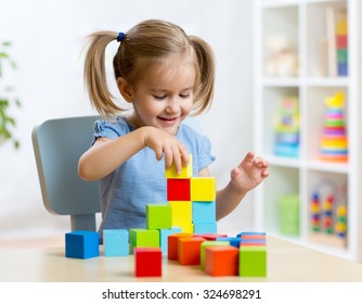 Child Little Girl Playing Wooden Toys At Home Or Kindergarten