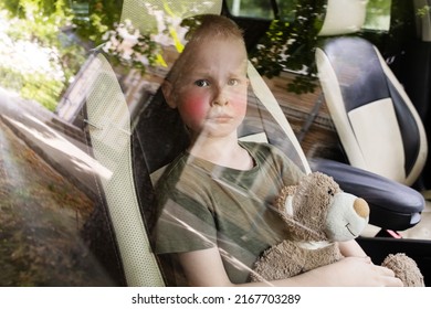 Child Locked In Car. Blond Boy Is Closed In Auto Without Water. He Is Hot And His Face Is Red. Concept Of Poor Care For Kids.