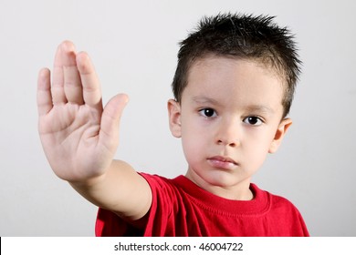 Child Looking At Camera. Stop Signal With His Hand. Over White Background