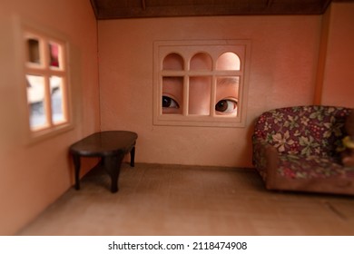 A child looking into a dollhouse through a window