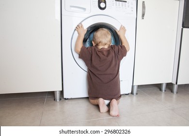 Child Is Looking Into The Washing Machine