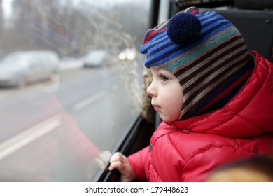 Child Looking Out The Window Of A Bus