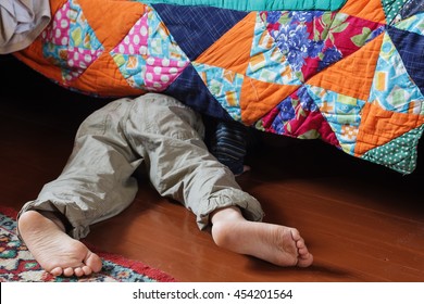 Child Looking For Something Under The Bed.