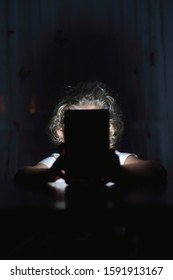 Child Looking At Tablet Screen In Dark Bedroom Background, Concept Of Screen Addiction And Personal Data Safety For Children.