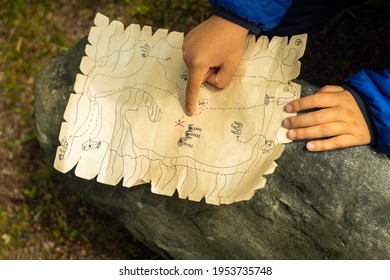 The Child Is Looking For A Treasure On The Children's Pirate Map.