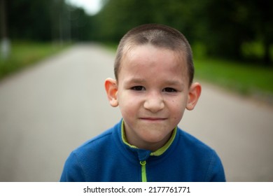 Child Looks Into Frame. Schoolboy With Short Haircut. Boy With Big Ears. Child On Street. Close-up Of Face.