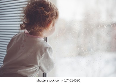 A Child Looks Out The Window.