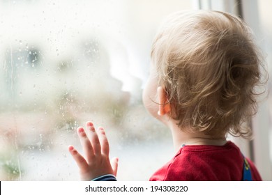 A Child Looks Out The Window