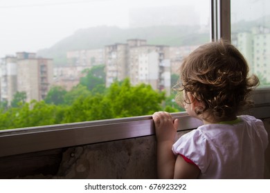 The Child Looks Out The Window. Lonely Child