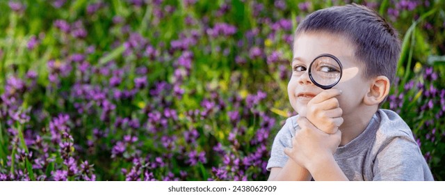 A child looks through a magnifying glass. A big child's eye - Powered by Shutterstock