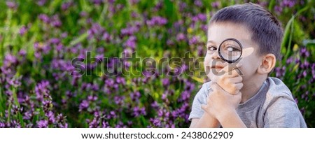 A child looks through a magnifying glass. A big child's eye