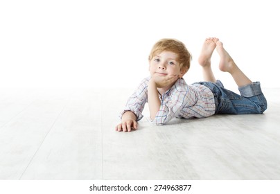 Child Lying Down On Floor, Kid Boy Over White Background, Looking At Camera