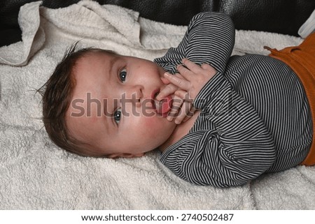 child lying on a sofa while his mother prepares him