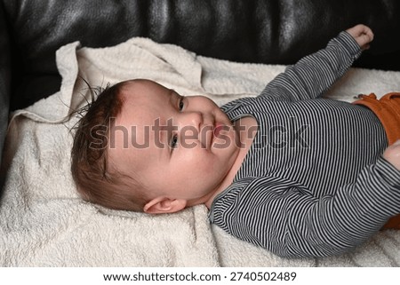 child lying on a sofa while his mother prepares him