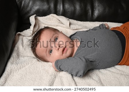 child lying on a sofa while his mother prepares him