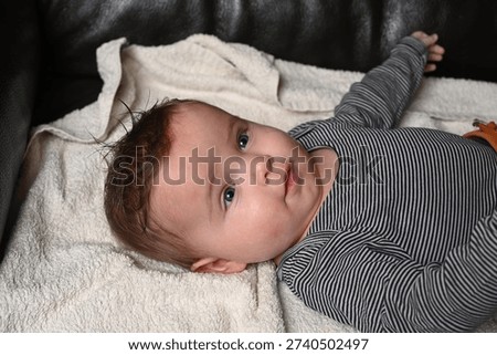 child lying on a sofa while his mother prepares him